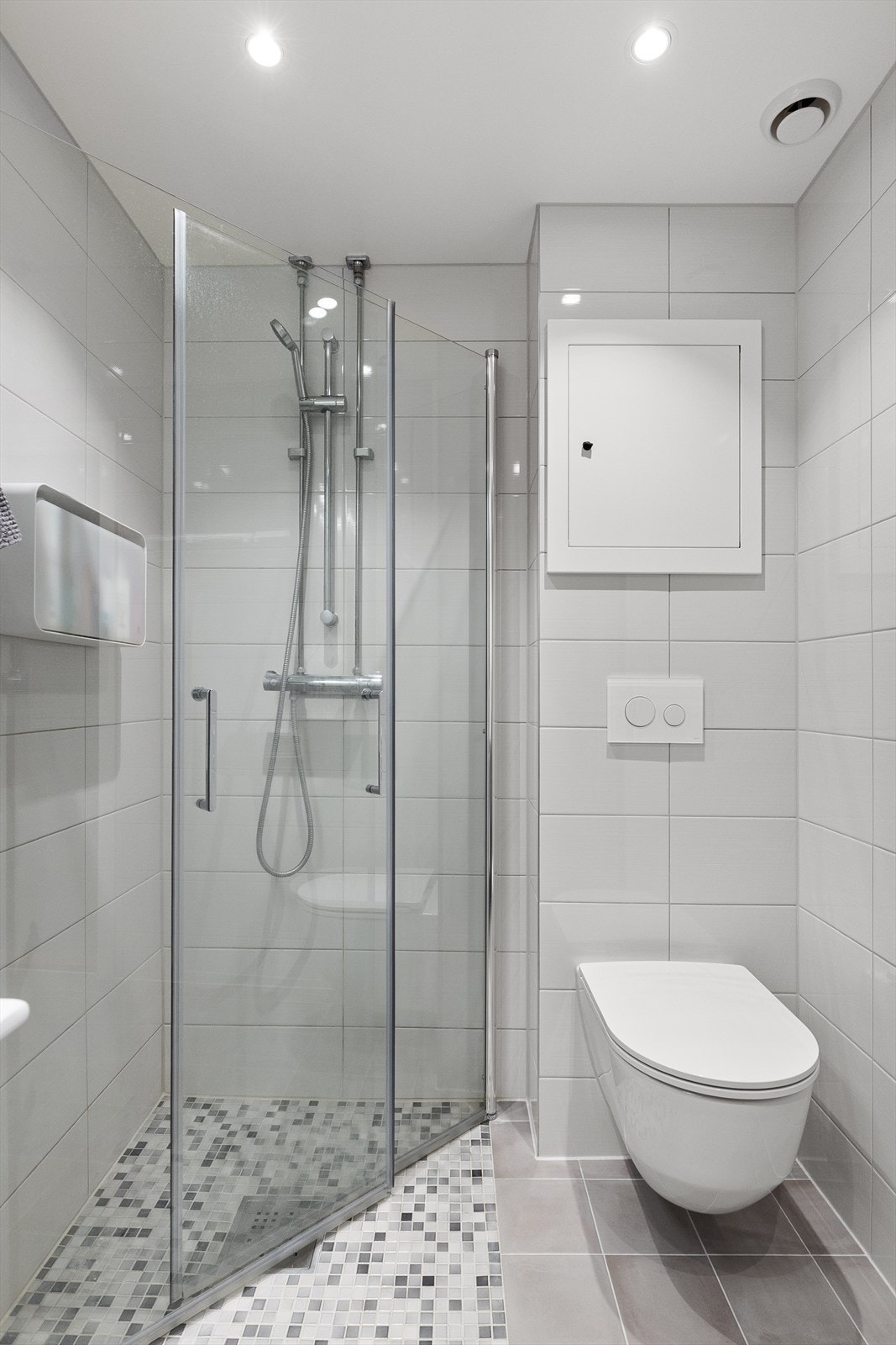 Innredningen i baderommet består forøvrig av vegghengt klosett og dusjhørne med innfellbare dusjdører i herdet glass Galleribilde