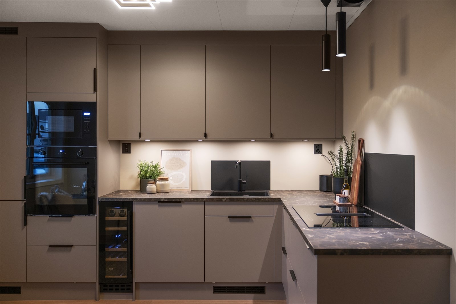 Integrerte hvitevarer som kjøl-fryseskap, stekeovn, mikrobølgeovn, platetopp og vinkjøler. Galleribilde