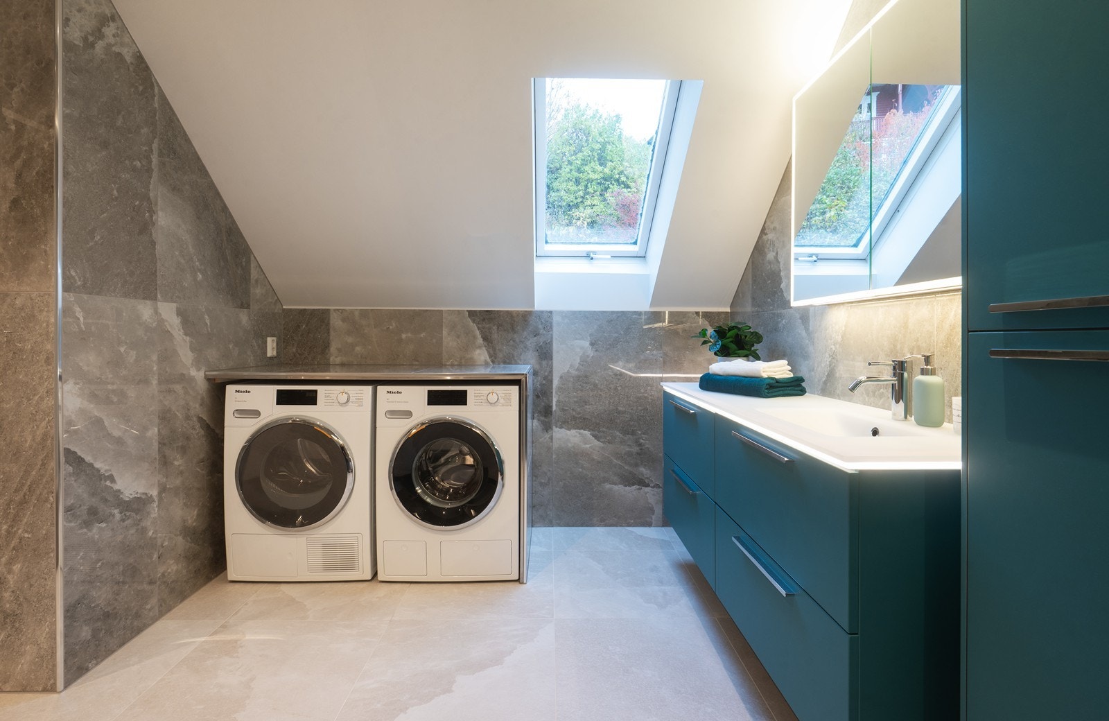 Under den flislagte benken finner du opplegg for både vaskemaskin og tørketrommel - en smart og diskré løsning som ivaretar helhetsinntrykket Galleribilde
