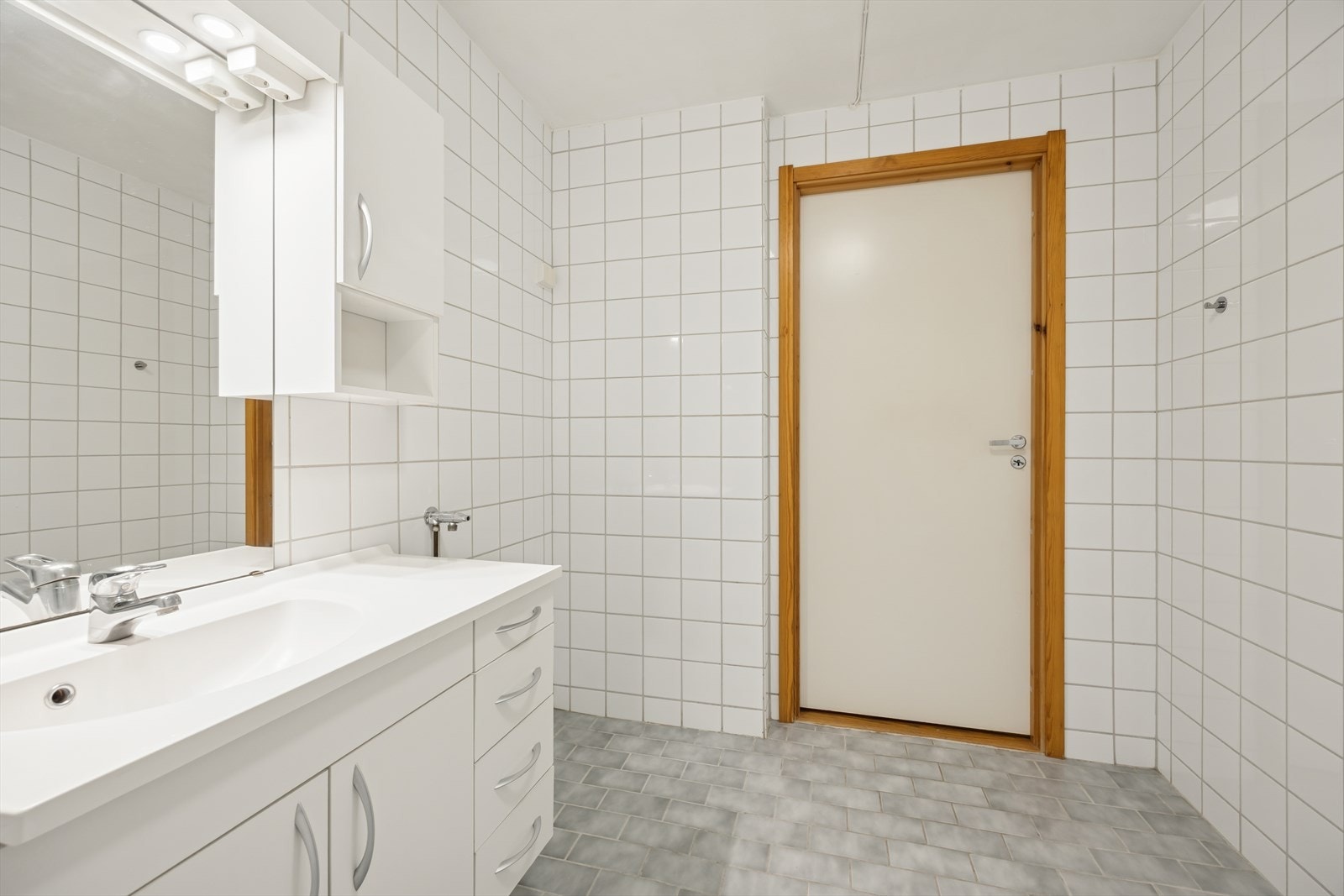 Romslig bad innredet med dusjnisjé, toalett, servant og innredning. Opplegg for vaskemaskin. Galleribilde