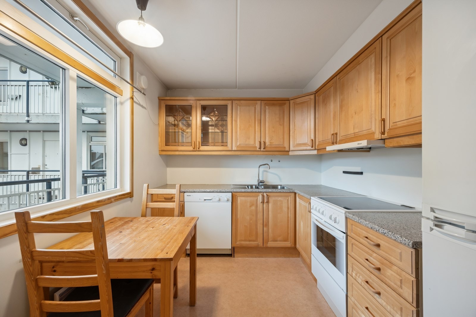 Kjøkken fra byggeår. Flere i borettslaget har flyttet kjøkkenet ut til stuen. Galleribilde