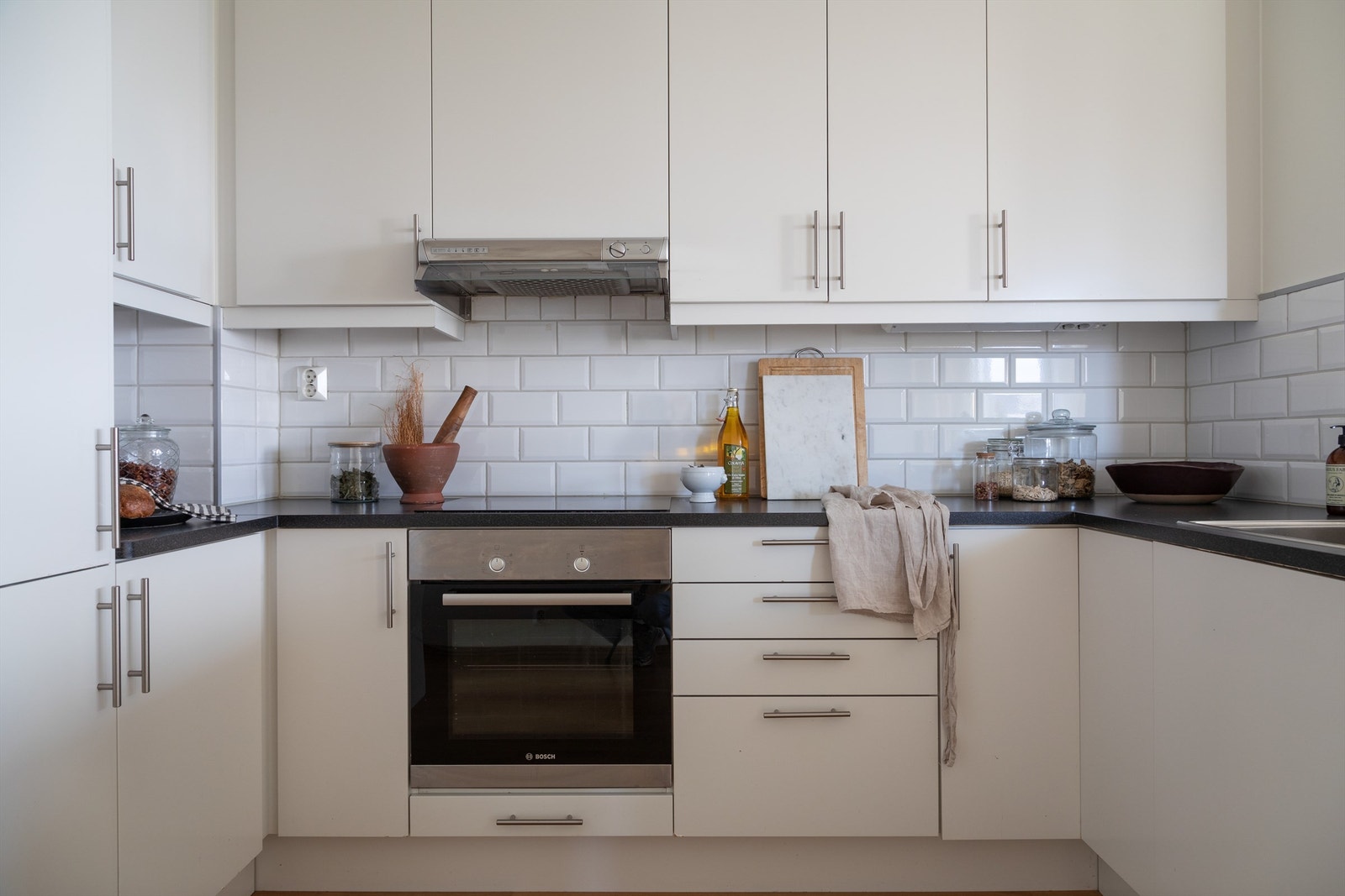 Innredningen fra Marbodal består av glatte fronter og benkeplate av laminat. Videre er det integrerte hvitevarer som kjøl/fryseskap, oppvaskmaskin, stekeovn og induksjonstopp. Galleribilde