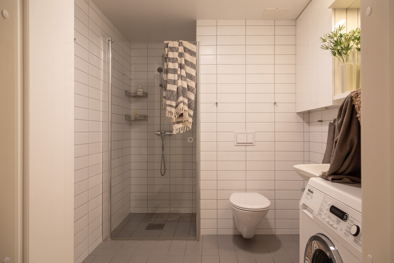 Baderommet er flislagt og har standard fra byggeår. Det er elektriske varmekabler i gulv og opplegg til vaskemaskin. Galleribilde