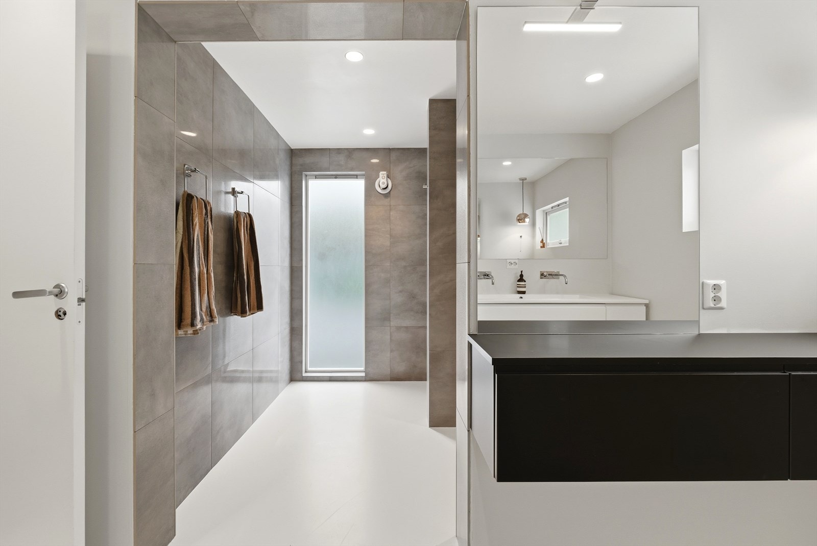 Baderommet er fordelt over flere soner, med gjennomgående naturlig lysgjennomslipp. Galleribilde