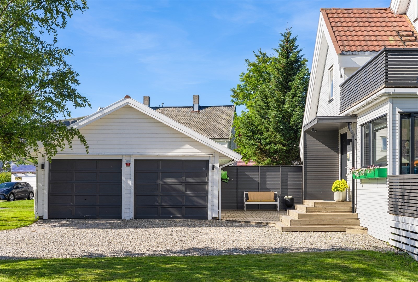 Mellom huset og garasjen er det oppført en markterrasse med levegg i bakkant. Galleribilde