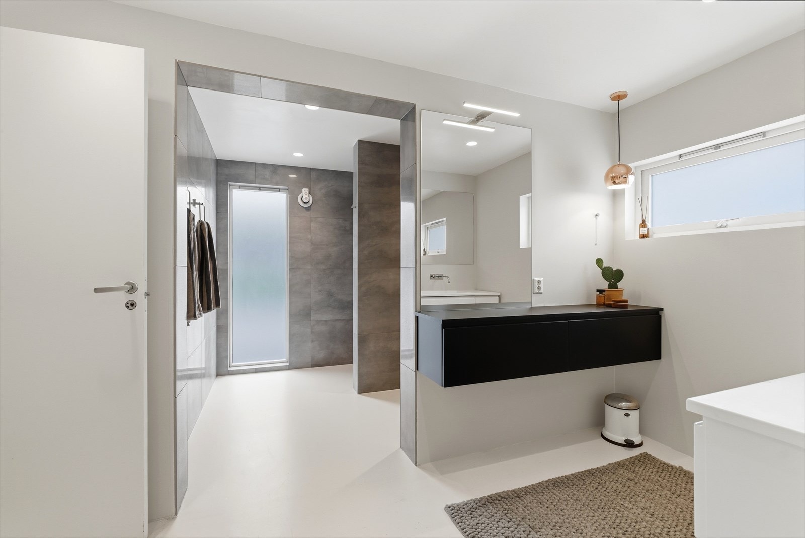 Ytterste sone, nærmest soverommet, har motstående oppbevaringsløsninger og speil. Galleribilde