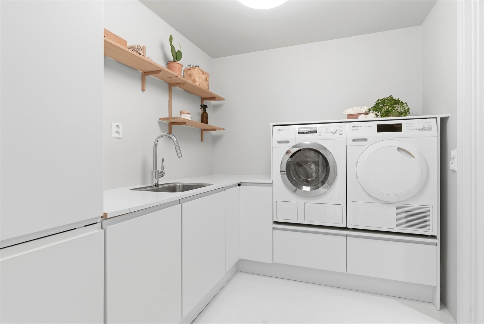Vaskerommet er tilbaketrukket, stilrent og godt utnyttet. Innredningen er tidløs og har praktisk utslagsvask. Galleribilde