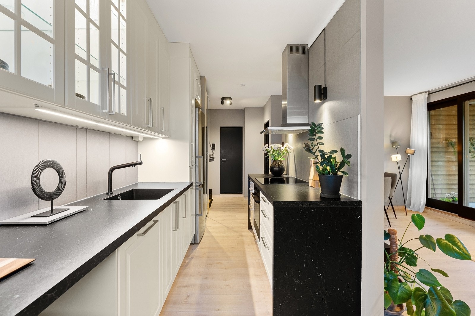 Innredningen er utført i hvite profilerte fronter på skapdører og skuffer, samt noen vitrinedører i glass Galleribilde