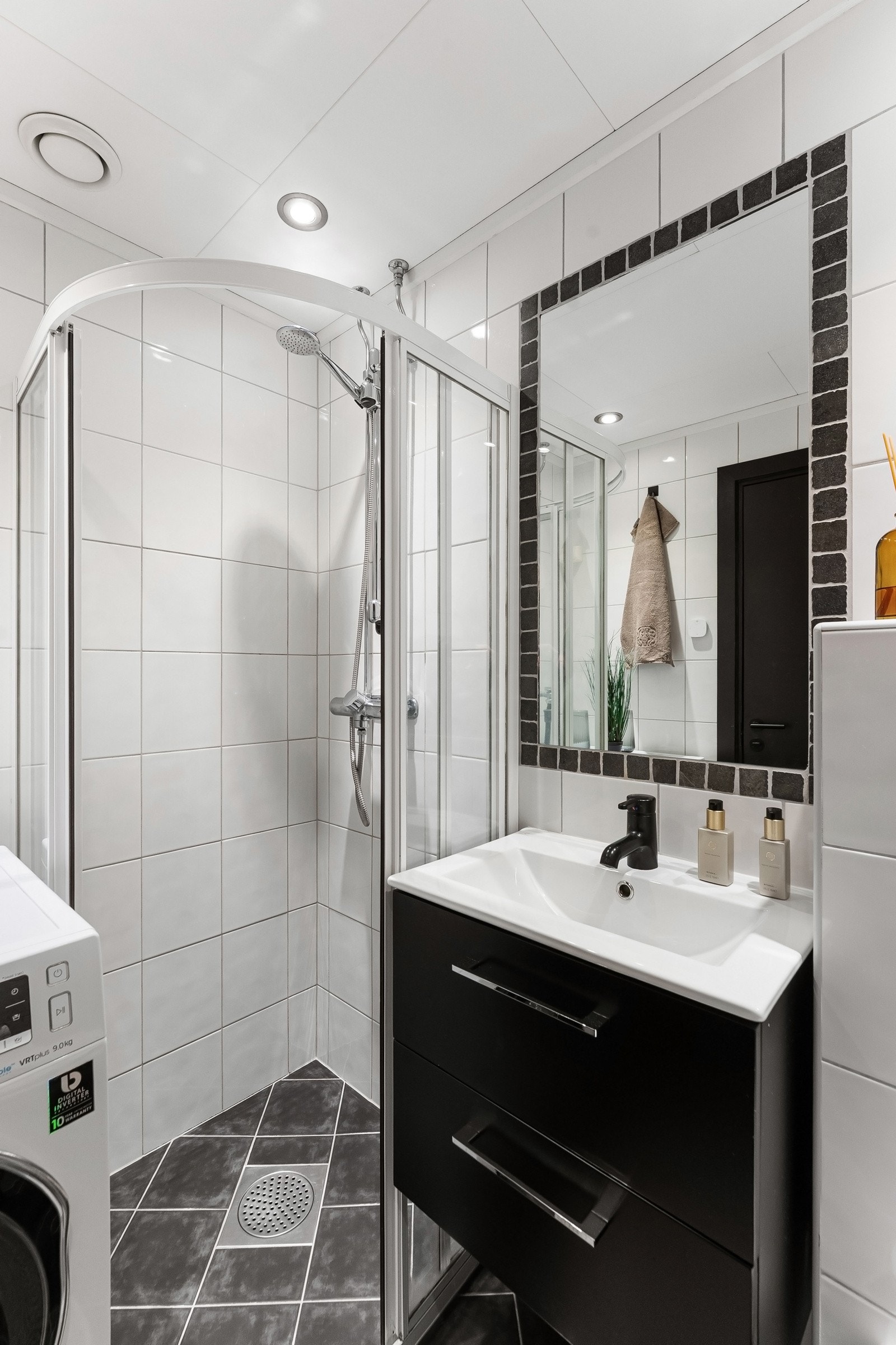 Rommet er utstyrt med dusjhjørne med skyvedører, veggmontert klosett og opplegg for vaskemaskin Galleribilde