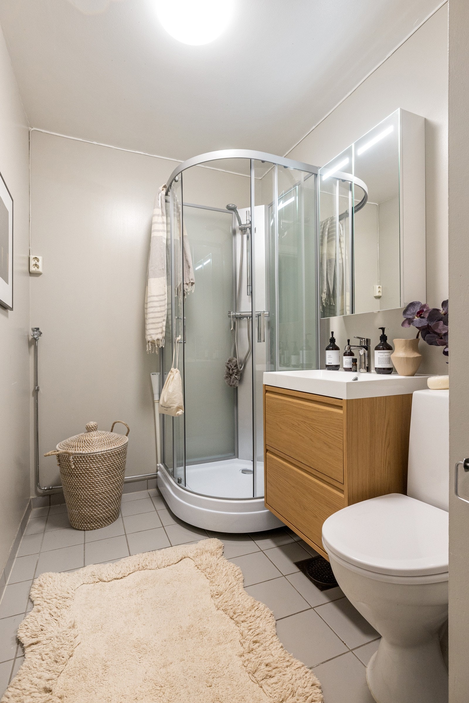 Eldre bad utstyrt med dusjkabinett, gulvmontert toalett og servantskap, samt opplegg for vaskemaskin. Galleribilde