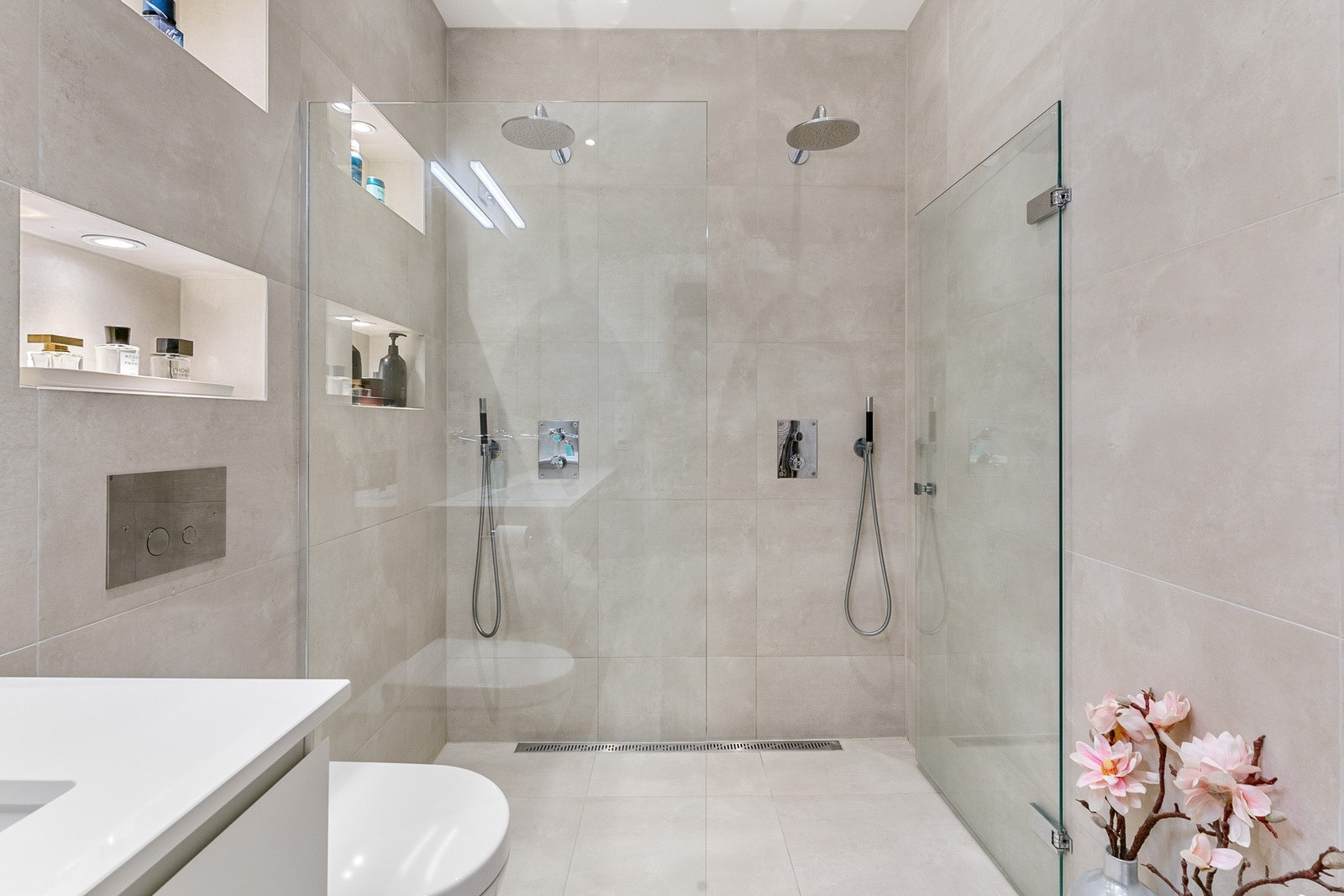 Dobbel servant med innebygde armaturer fra Hansgrohe, veggmontert toalett fra Villeroy & Boch, dusjvegger/hjørne, speil m/lys og opplegg til vaskemaskin. Galleribilde