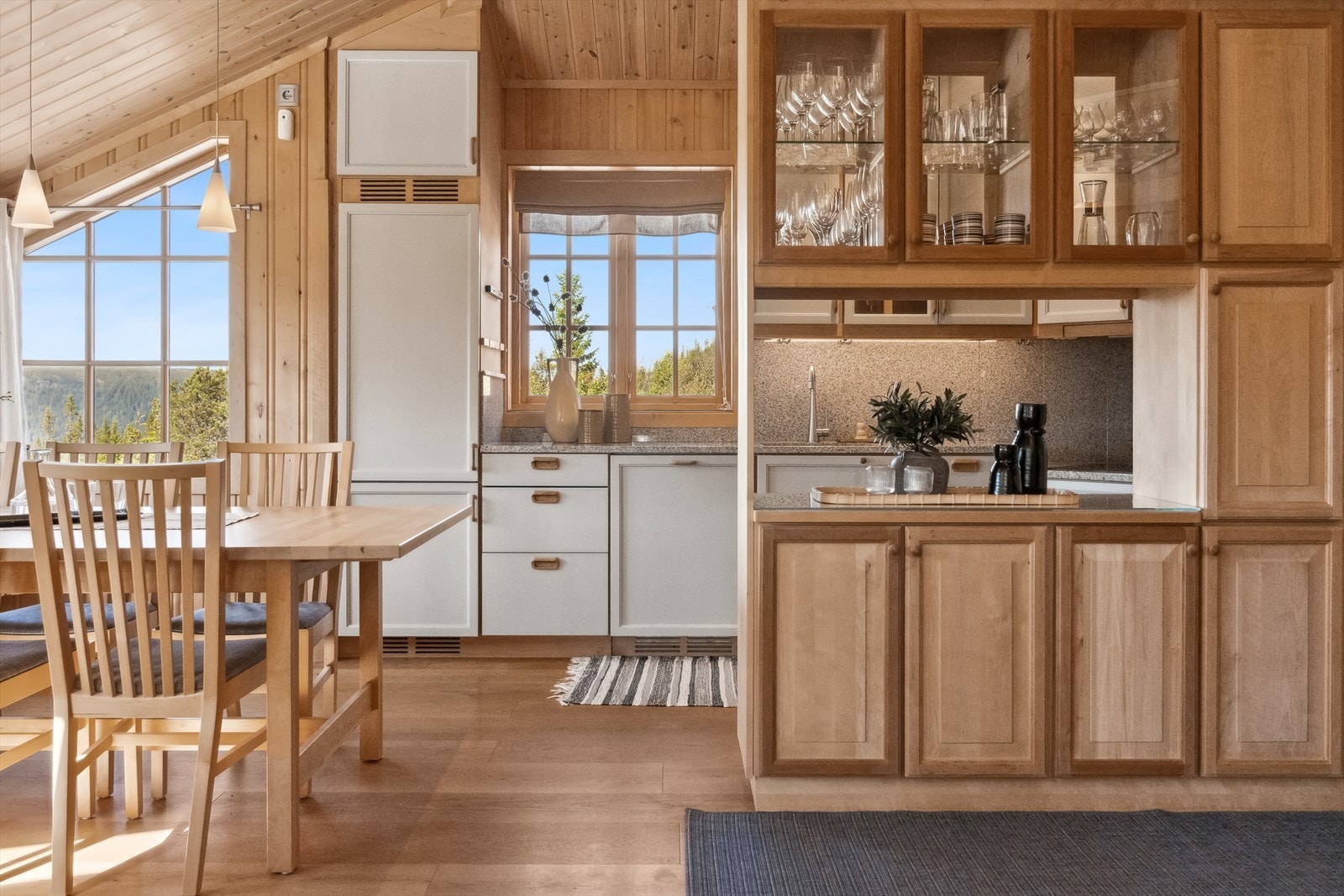 Lekker kjøkkenløsning med rikelig med skap- og benkeplass, åpnet mot stuen men skjermet av elegante skap, som gir både funksjonalitet og stil. Galleribilde