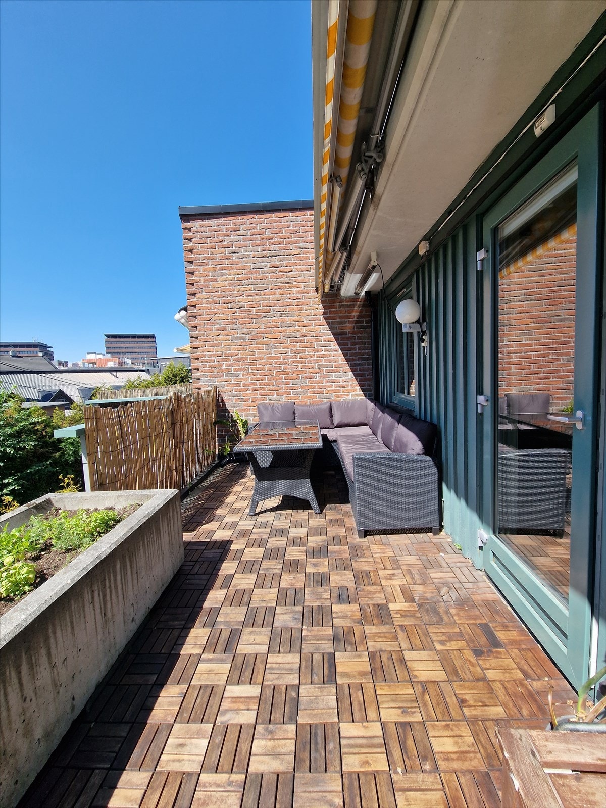 Sommer på balkongen med gode solforhold - her belagt med terrasseheller i tre. Selgers private bilde. Galleribilde