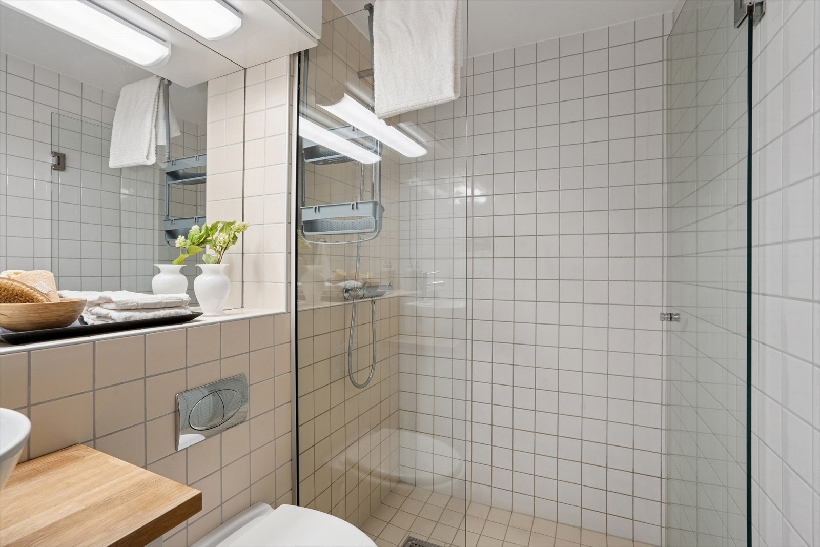 Romslig dusjsone er avgrenset med dusjvegg og dusjdør. Galleribilde