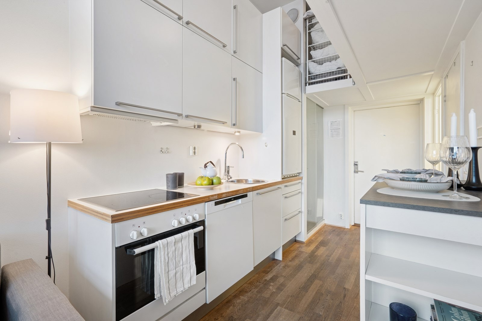 HTH kjøkkeninnredning med glatte, hvite skapfronter og overskap i 2 høyder. Galleribilde