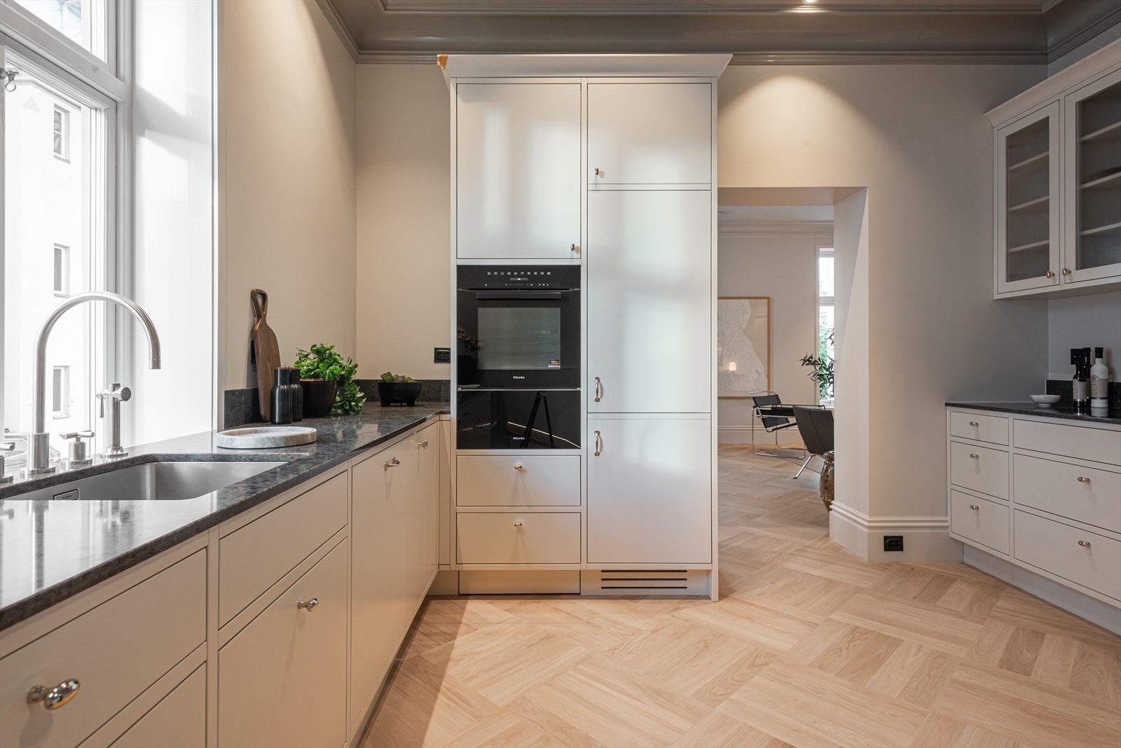 Kjøkkenet, som ligger delvis adskilt fra stuen, er et høykvalitetskjøkken i lekker og tidløs utforming spesialbygget av møbelsnekkerverksted Galleribilde