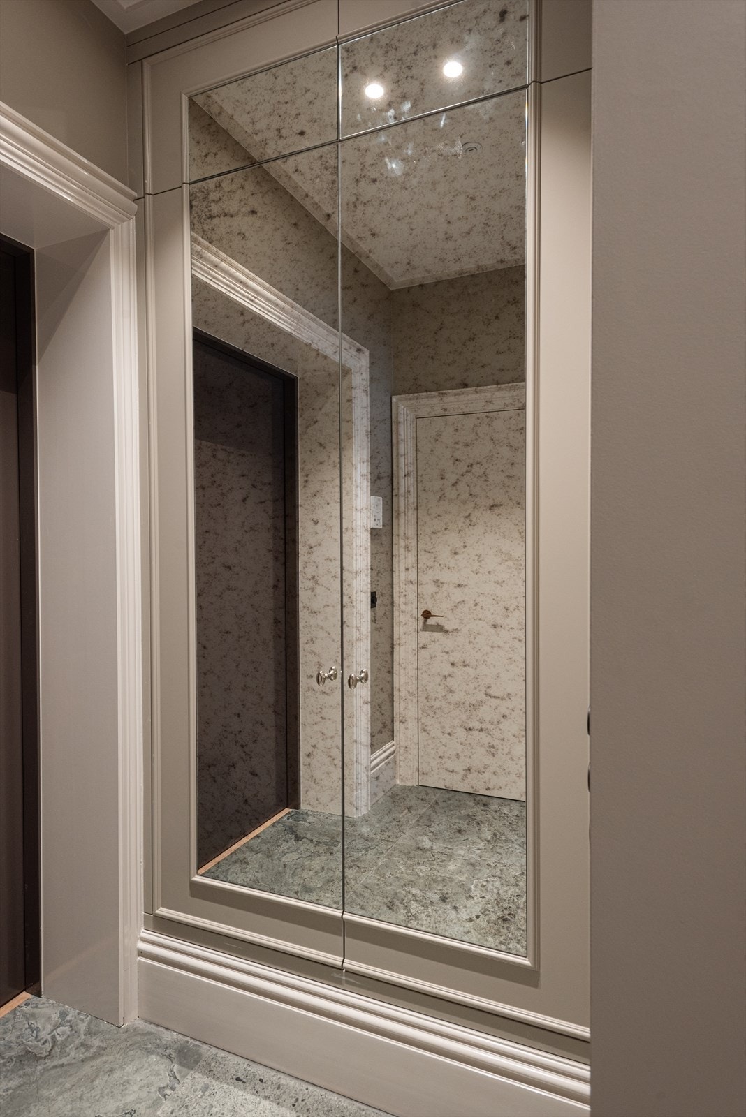 Leiligheten har en meget innbydende entré med flislagt gulv med gulvvarme, en tilpasset garderobeløsning med skohylle og antikkspeil Galleribilde