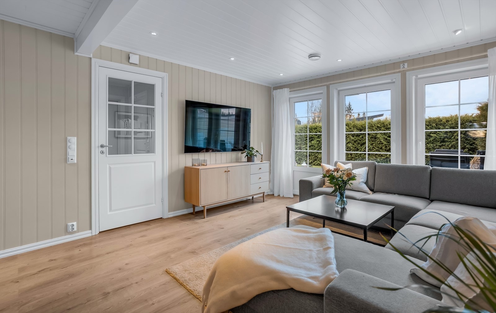 Store vindusflater gir rikelig med naturlig lys inn i stuen. Galleribilde