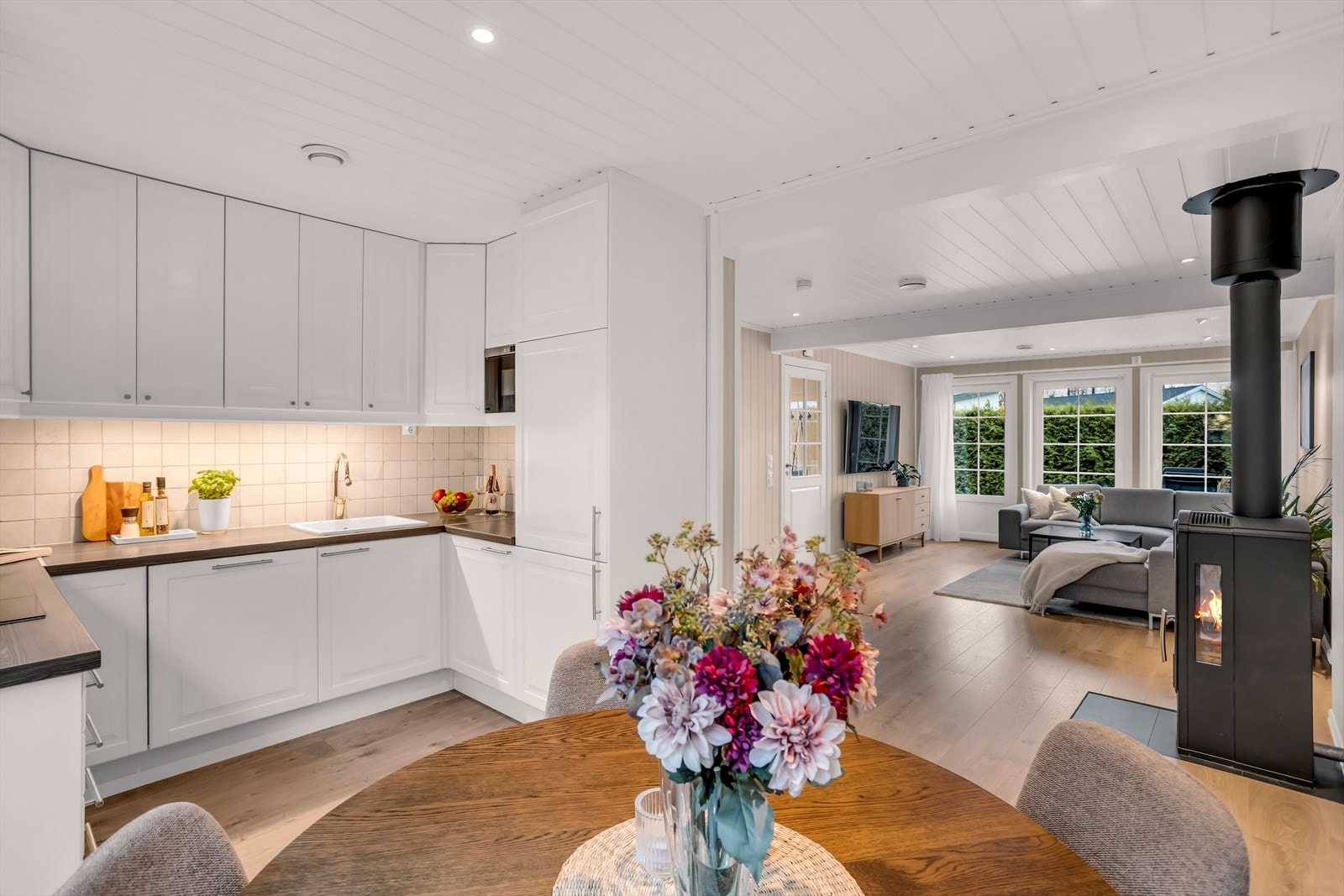 Kjøkkenet har en praktisk U-formet innredning med profilerte, hvite fronter. Galleribilde