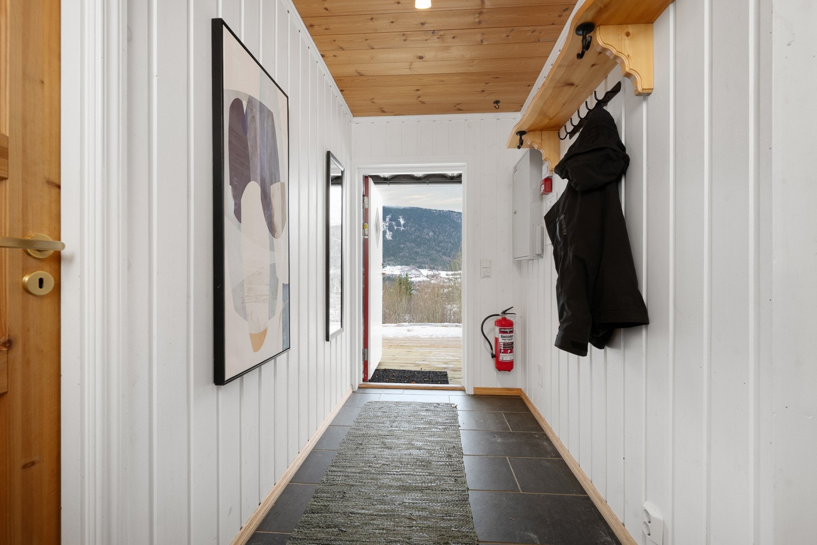 Når du kommer inn, møtes du av en lys og romslig entré med flislagt gulv og moderne, lyse vegger. Galleribilde