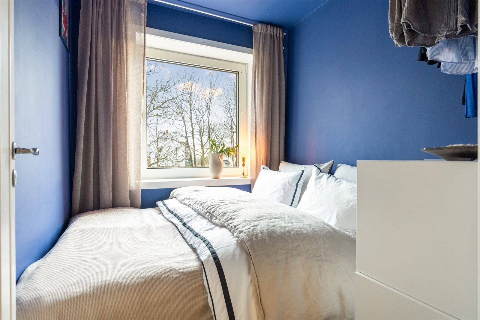 - Koselig soverom med plass til dobbeltseng og praktisk løsning for oppbevaring av klær - Galleribilde