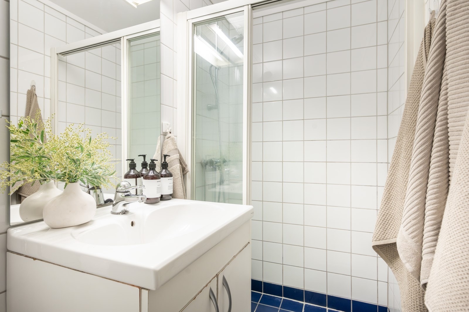 - Baderommet er innredet med servant på innredning, gulvstående toalett og dusjløsning - Galleribilde