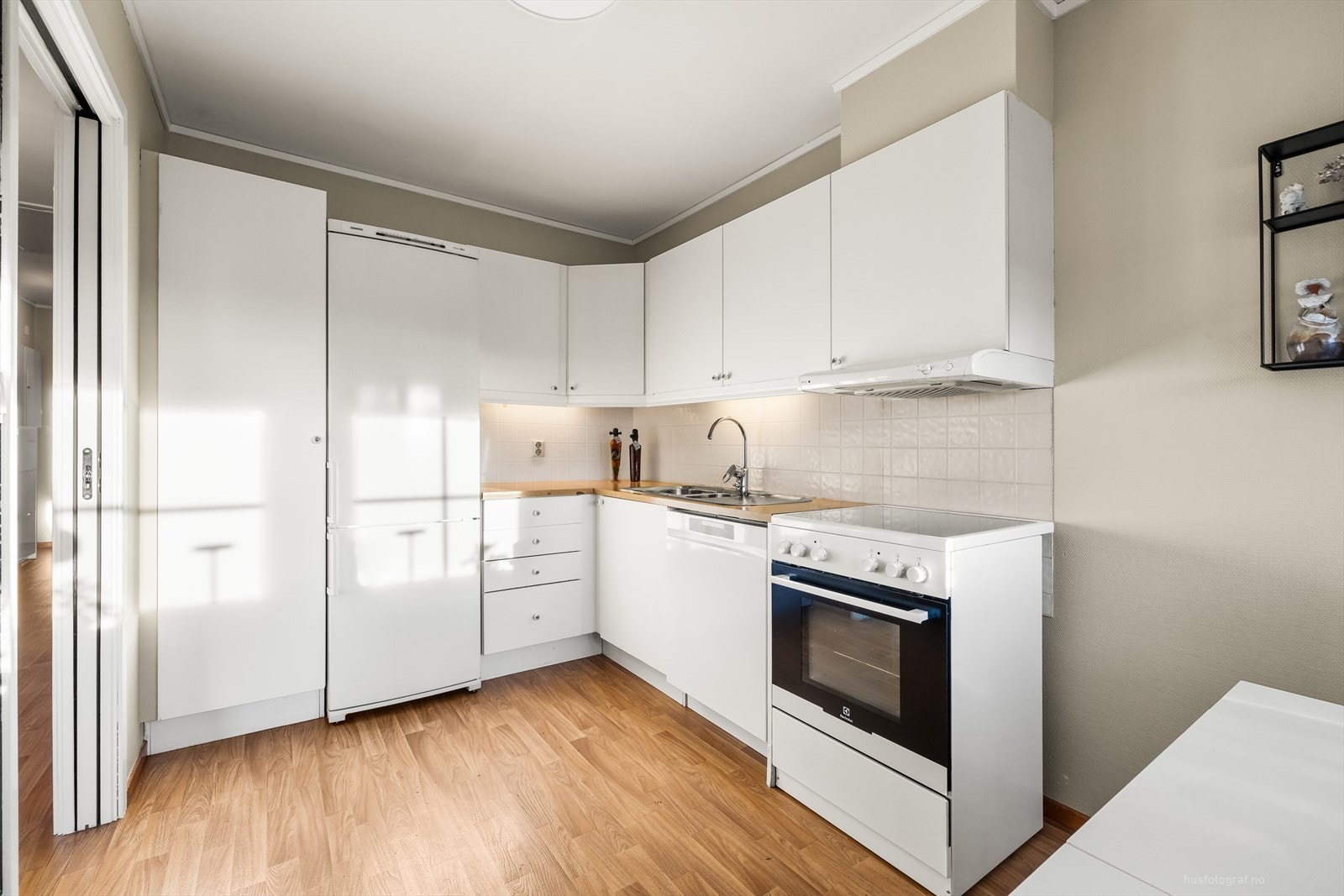 Eldre kjøkken med lyse glatte fronter og laminat benkeplate. Galleribilde