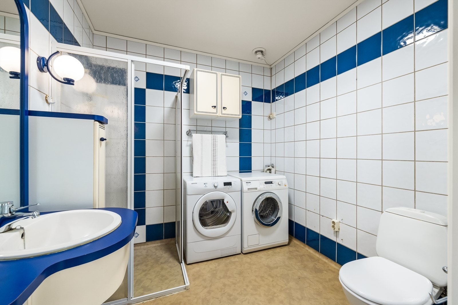 Rommet har innredning med nedfelt servant, toalett, dusjvegger/hjørne og opplegg for vaskemaskin. Galleribilde