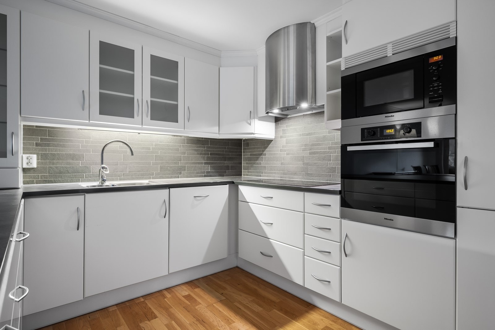 Lyst og fint kjøkken med integrerte hvitevarer Galleribilde