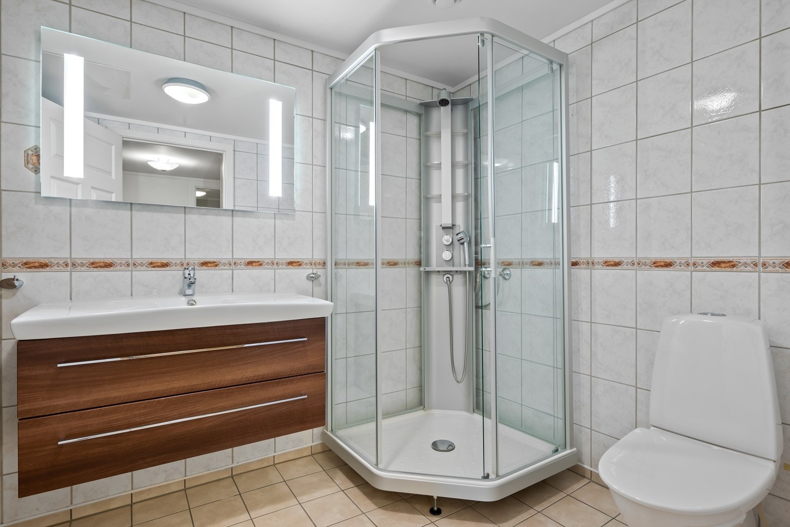 Badet er utstyrt med dusjkabinett, servantskap, wc og mekanisk avtrekk Galleribilde