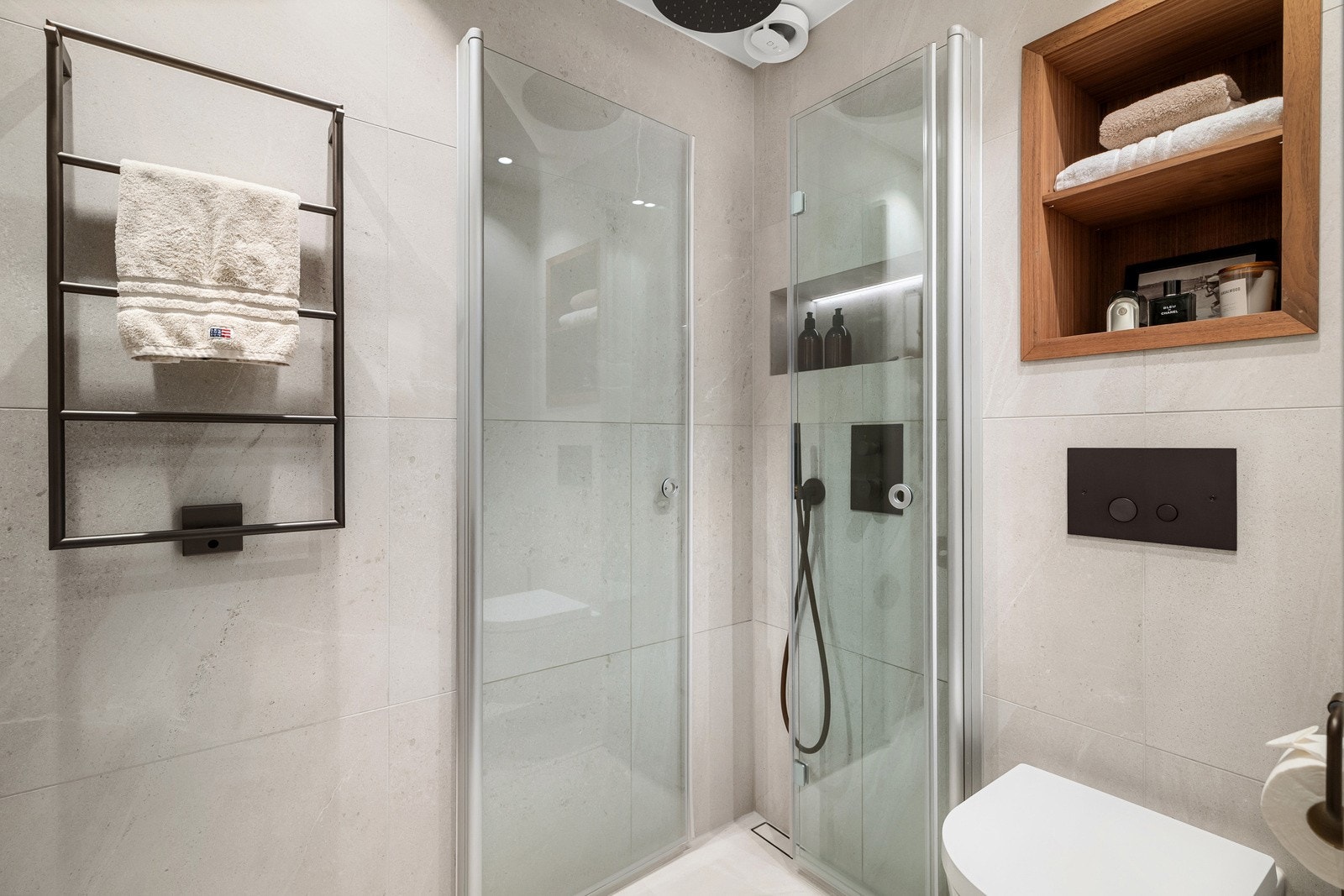 Det er vegghengt servantinnredning med god benke- og skapplass, speilskap med belysning, elektrisk håndkletørker, dusjhjørne med regndusj, vegghengt toalett og opplegg for vaskemaskin. Galleribilde