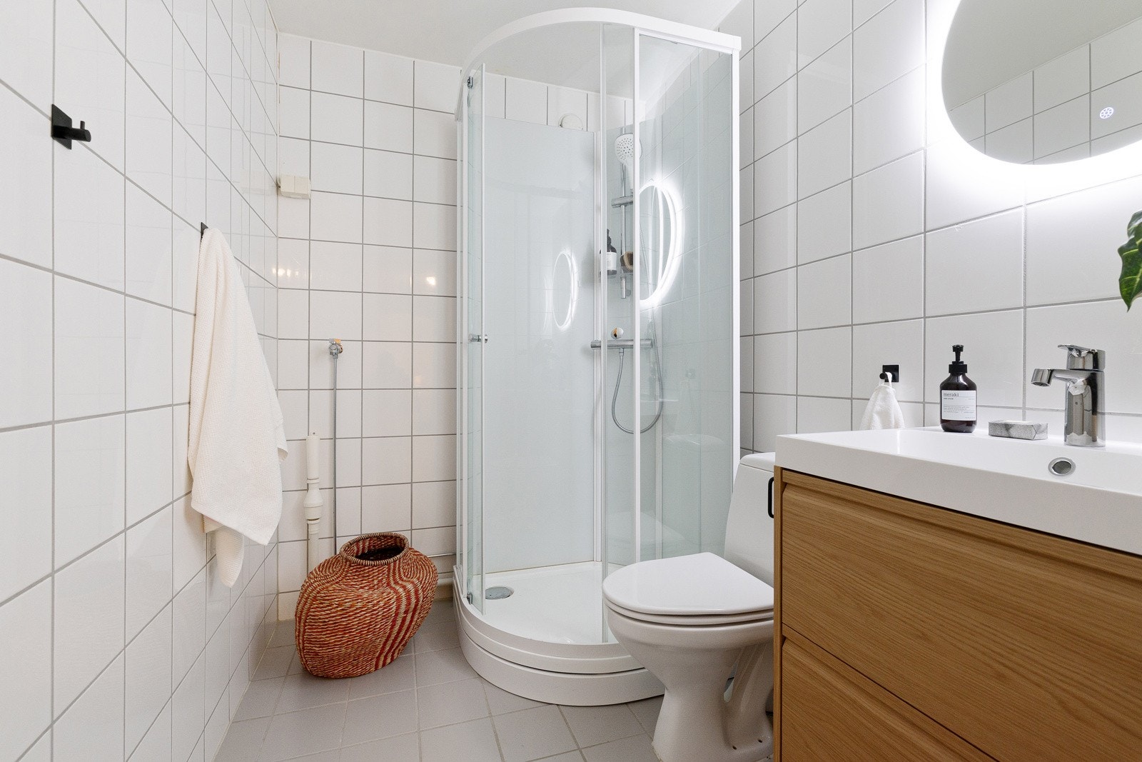 Badet er innredet med servantskap, moderne speil med belysning, dusjkabitnett og toalett. Galleribilde
