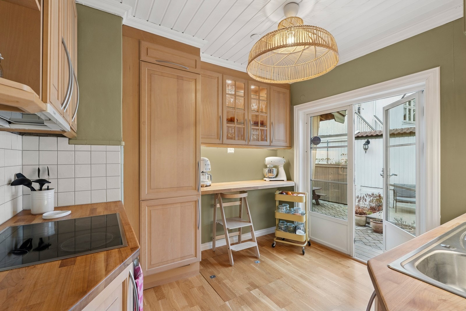 Med varme fargetoner og naturlige materialvalg fremstår kjøkkenet som både innbydende og funksjonelt. Galleribilde