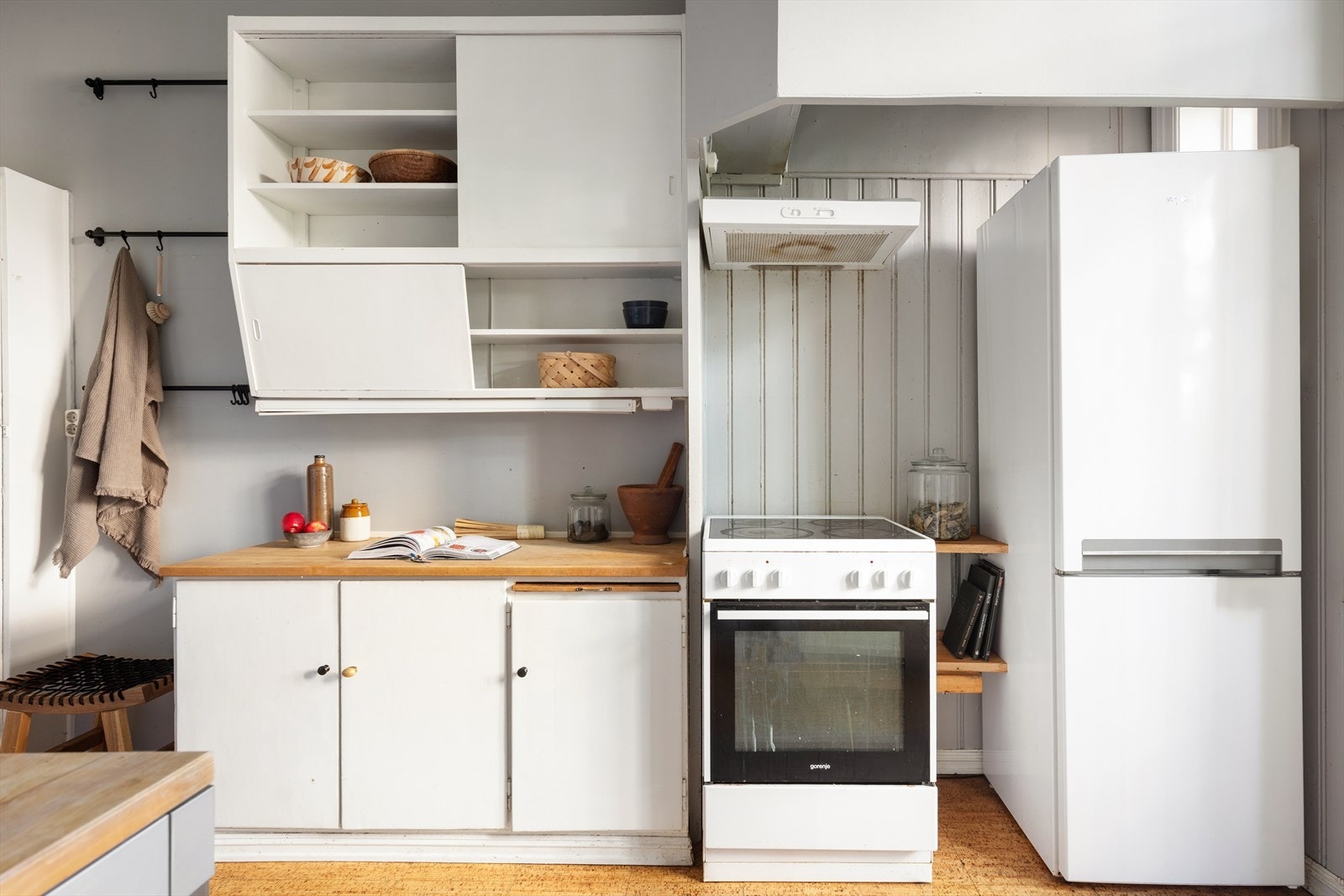 Eldre kjøkkeninnredning med slette fronter, malte overflater over benkeplate m/ oppvaskkum og bl.batteri. Galleribilde