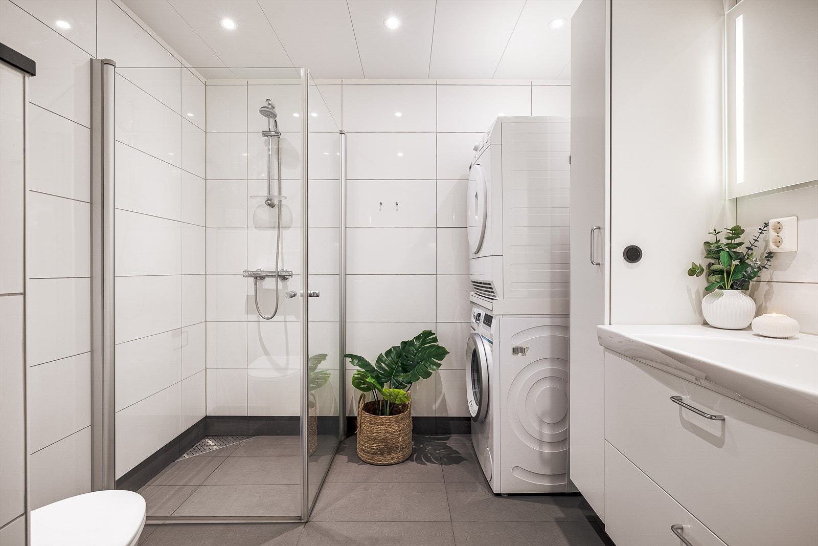 Pent bad med fliser på gulv/vegger og opplegg for vaskemaskin Galleribilde