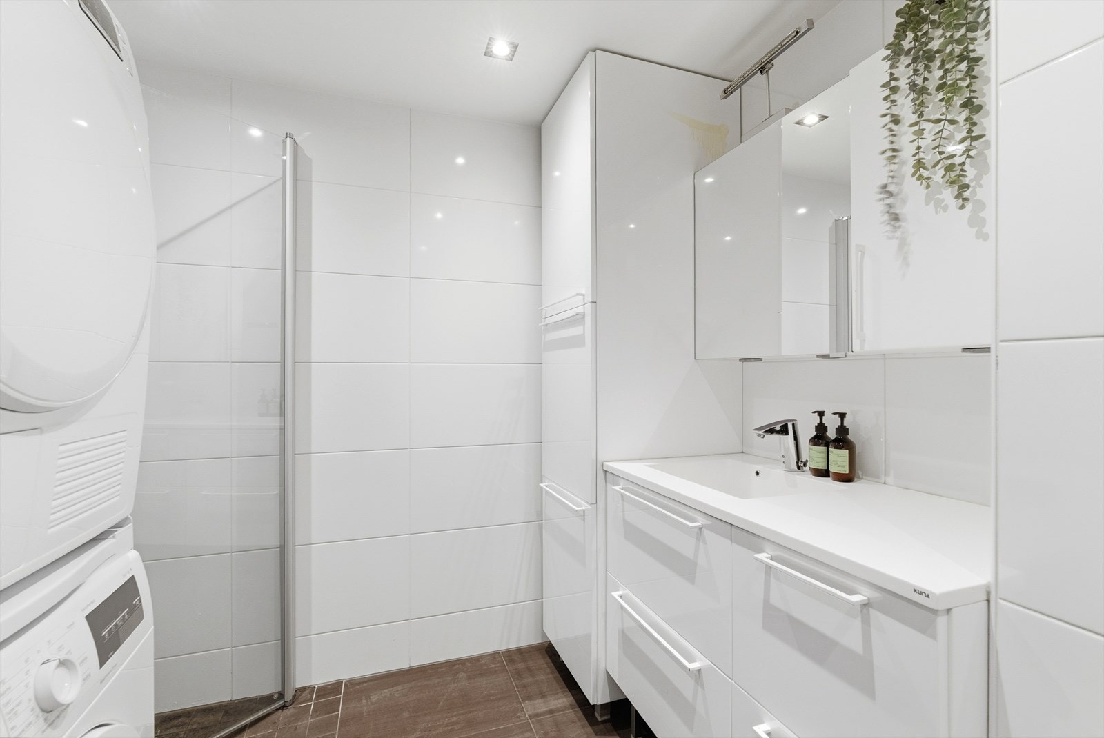 Baderommet er av god størrelse, med moderne innredning med skuffer og heldekkende servant, vegghengt toalett, opplegg for vaskemaskin, og dusjhjørne med innfellbare glassdører. Galleribilde