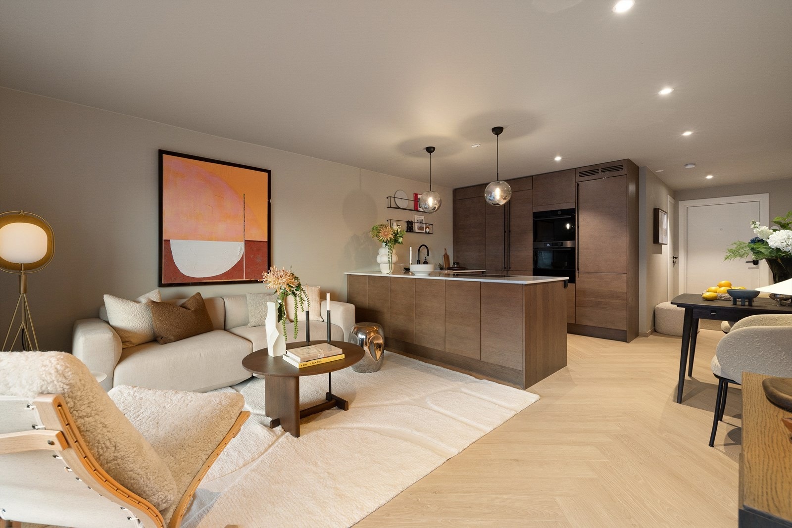 Åpent, romslig kjøkken i sømløs overgang til stue. Legg merke til ekstra lagringsplass på begge sider av kjøkkenøy. Galleribilde