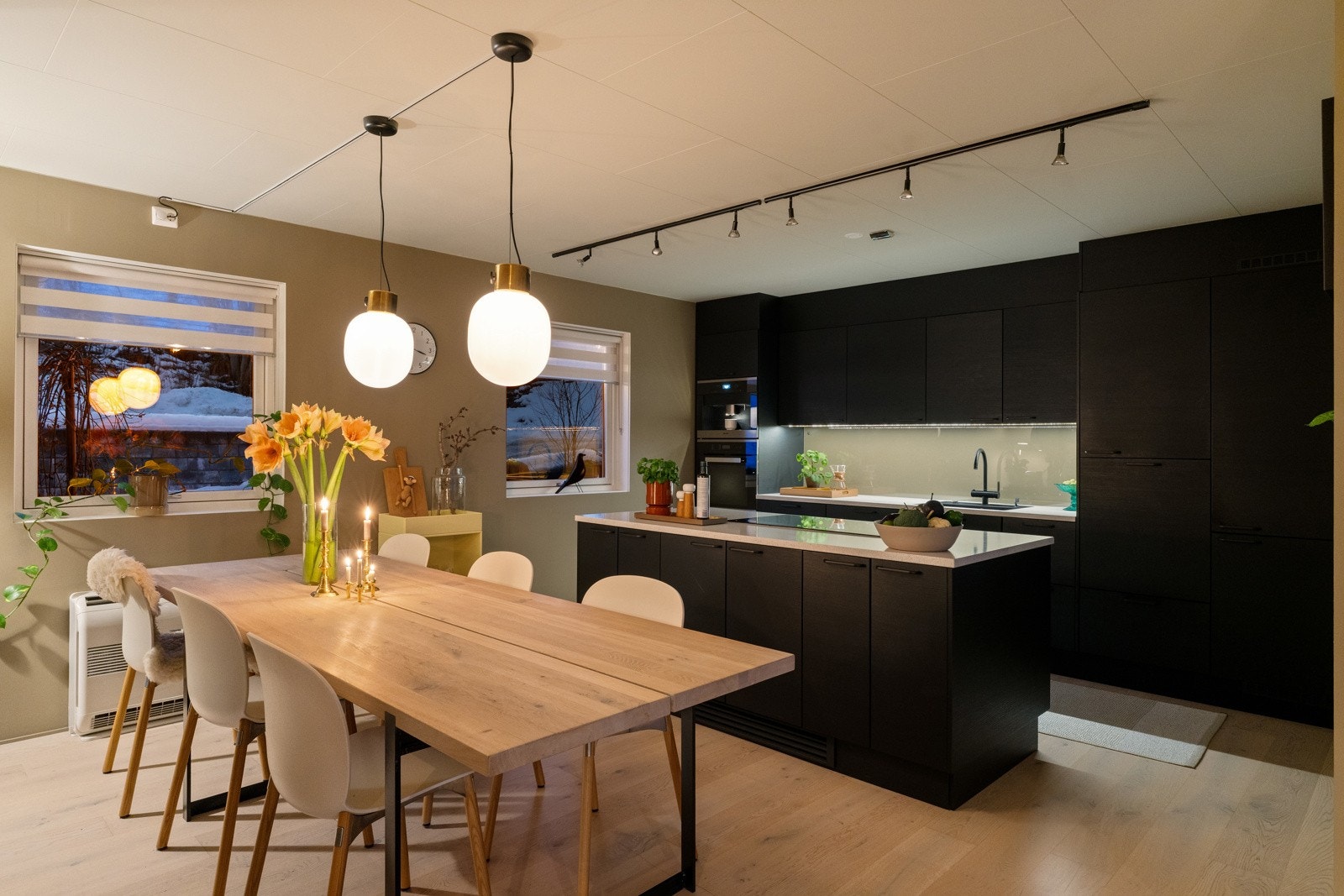 Kjøkken og spisestue faller naturlig sammen i en fin harmoni. Materialvalg, utformingen av kjøkkenet og fargevalget bidrar til et fint spill og gir et ekslusivt og skreddersydd preg. Galleribilde