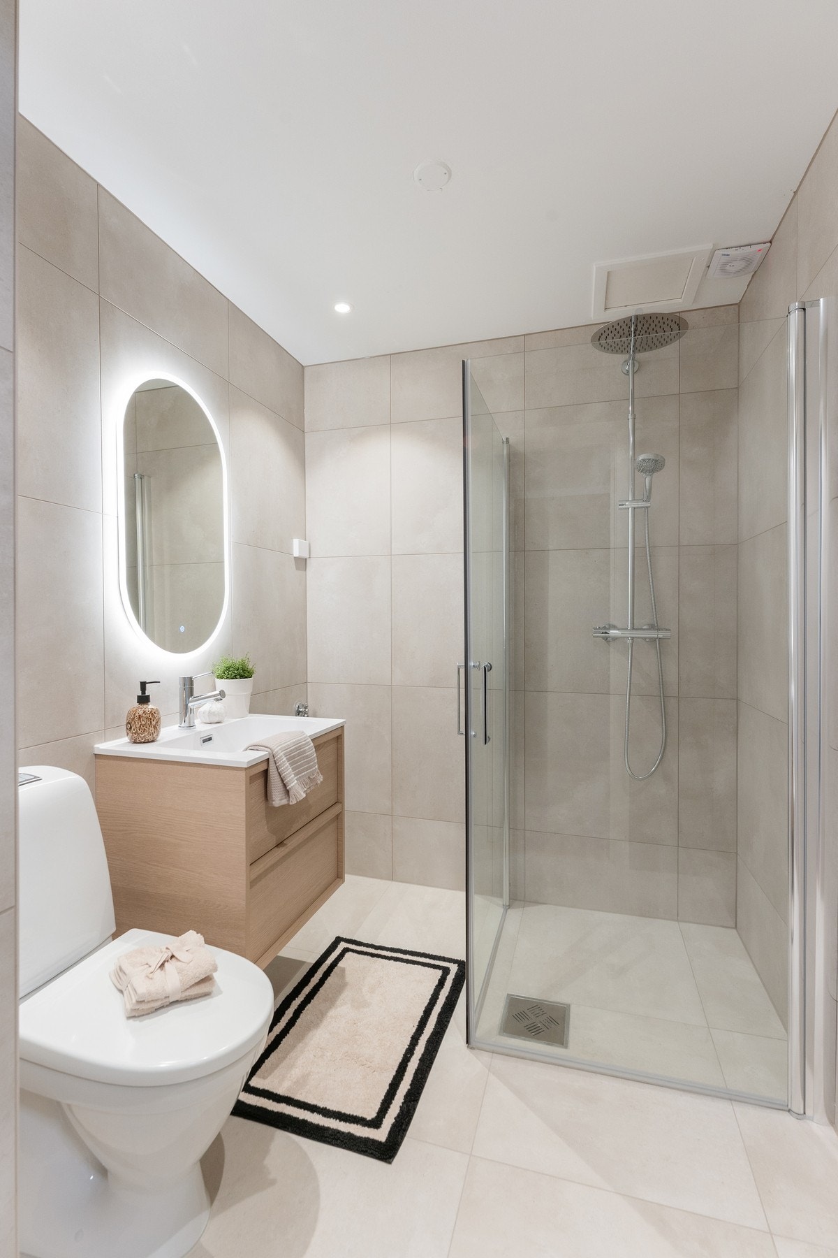 Moderne baderom delvis pusset opp i 2025. Lekre fliser med behagelig gulvvarme og opplegg for vaskemaskin. Galleribilde