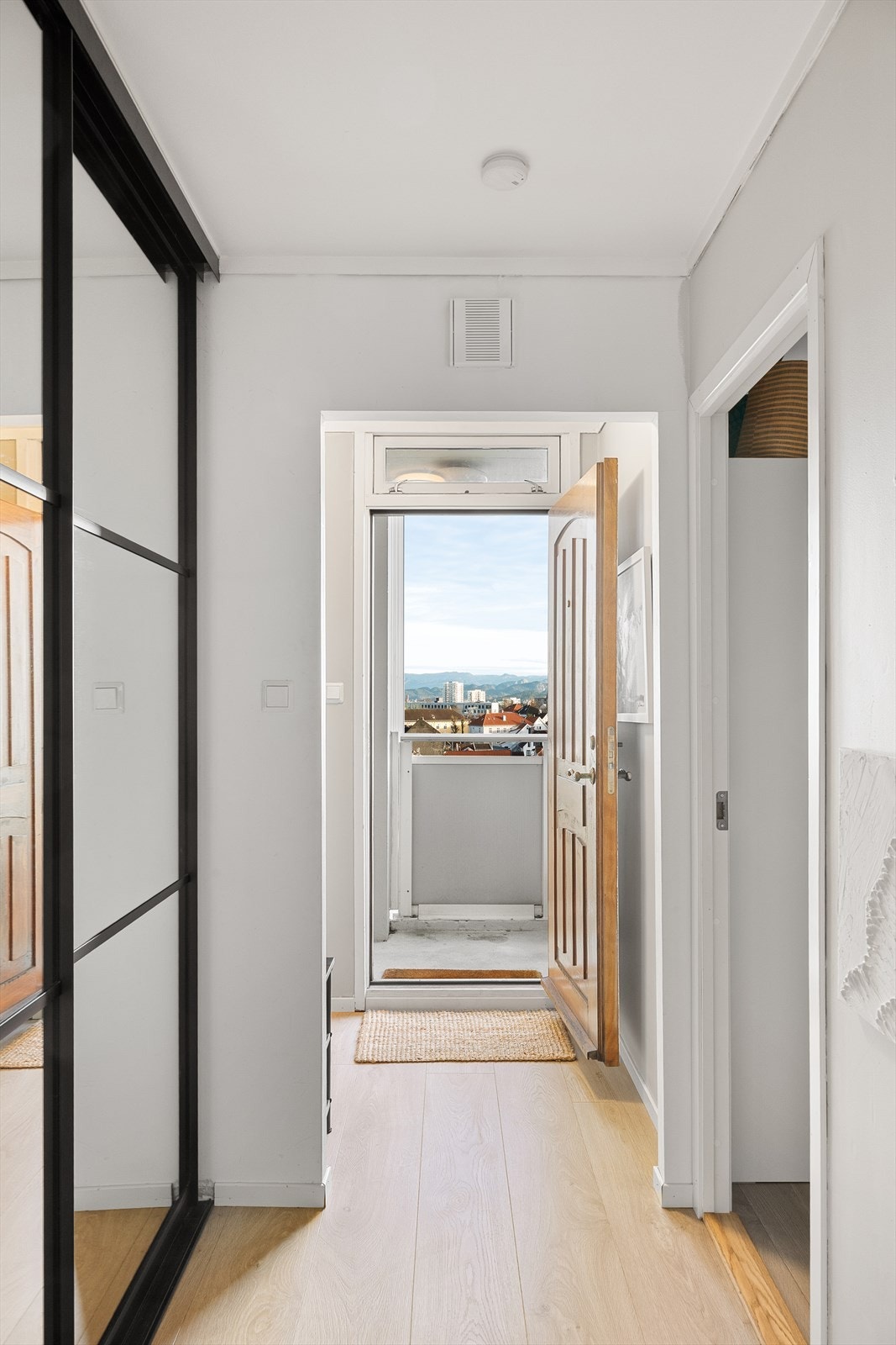 Romslig gang hvor det er installert stor skyvedørsgarderobe til lagring. Galleribilde