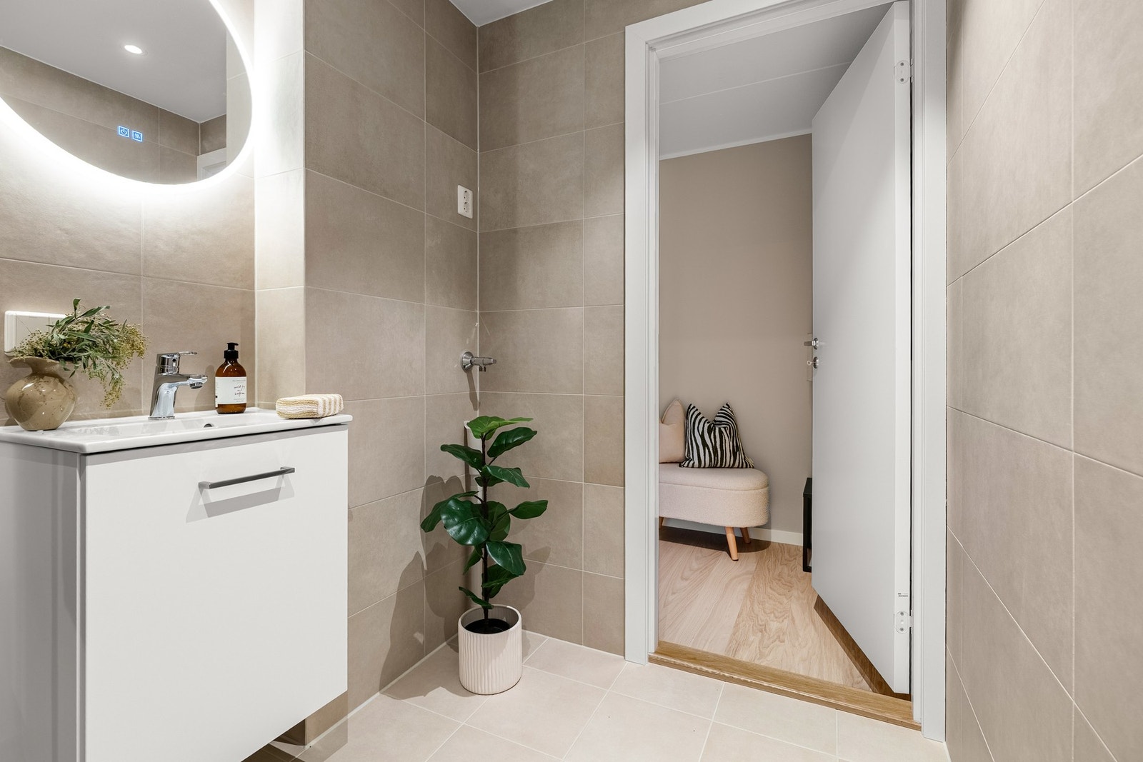 Bad med beige fliser på gulv og vegg Galleribilde