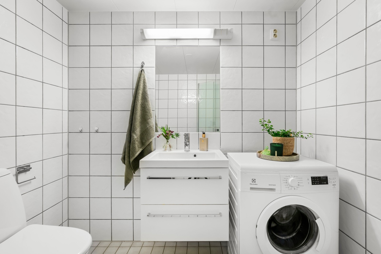 Rommet er innredet med servantskap, speil med belysning, dusjhjørne med svingdører og veggmontert toalett. Galleribilde