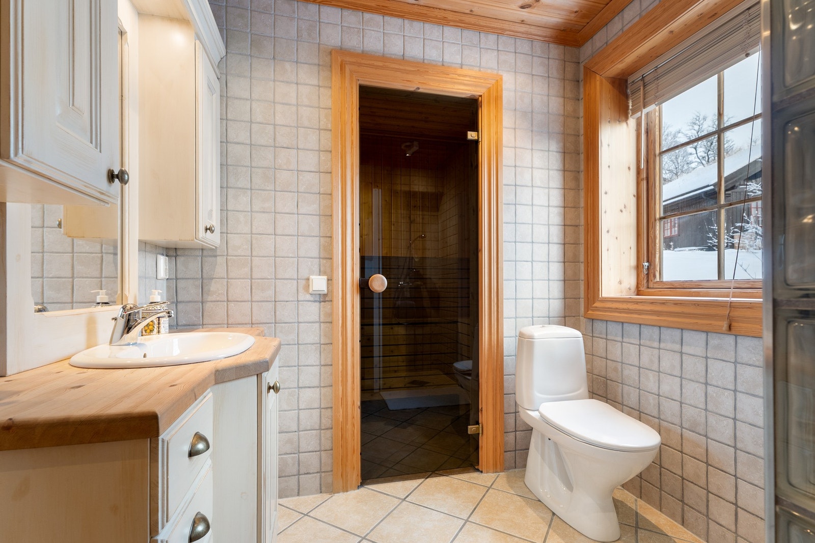 Hovedbad med toalett, innredning med servant, dusjnisje og tilgang til badstue Galleribilde