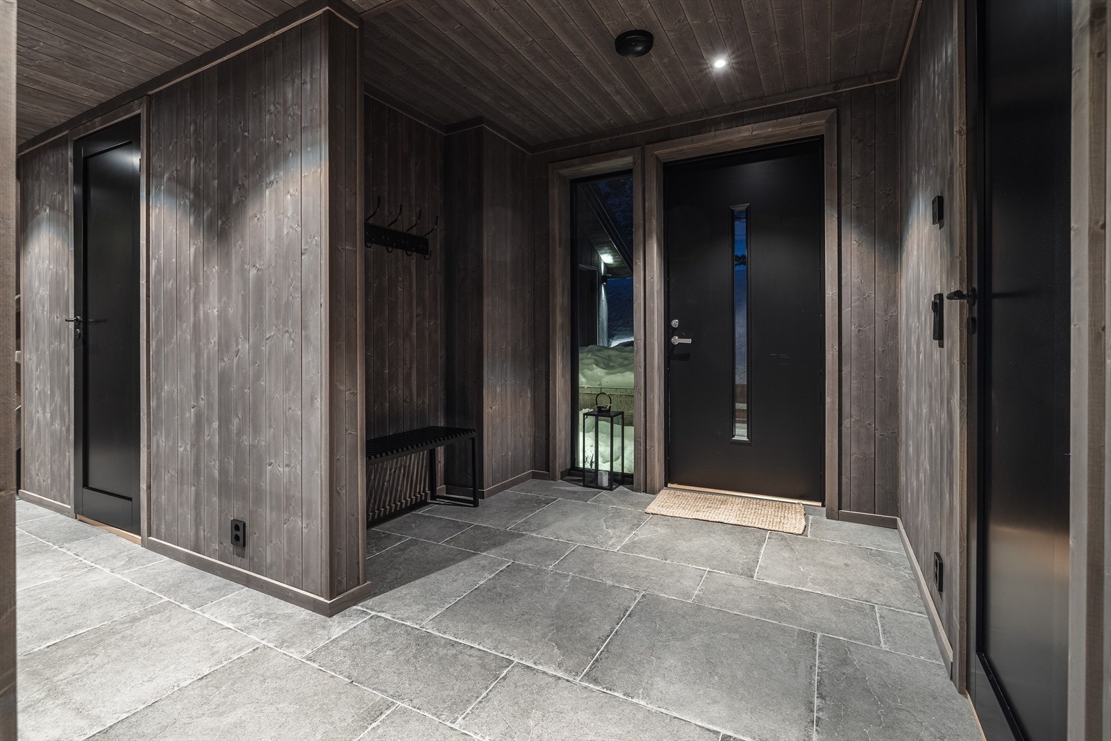 Moderne og gjennomført entré med robuste fliser og moderne detaljer. Galleribilde