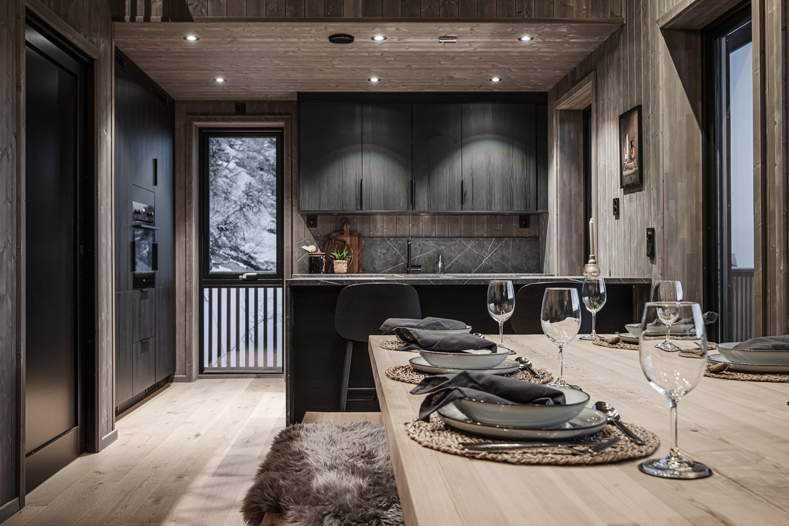 Moderne kjøkken med stilrene detaljer, integrerte hvitevarer og dimbare spotlights for stemningsfull belysning. Galleribilde