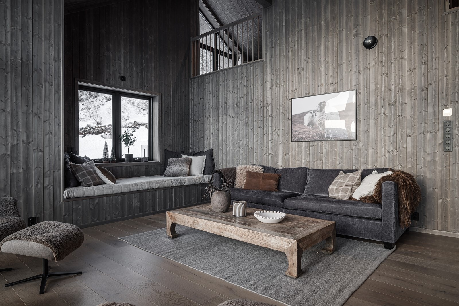 Lun og romslig stue med med snekkertilpasset sittegruppe i vinduet og åpen tilknytning til 2. etasje. Galleribilde