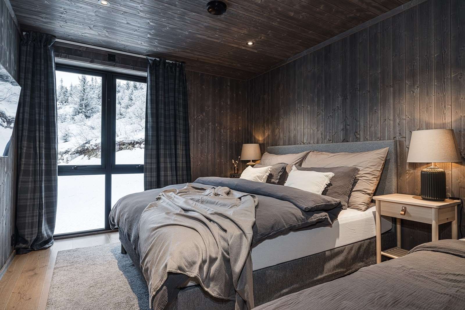 Lunt og innbydende hovedsoverom med store vindusflater som slipper naturen inn. Galleribilde