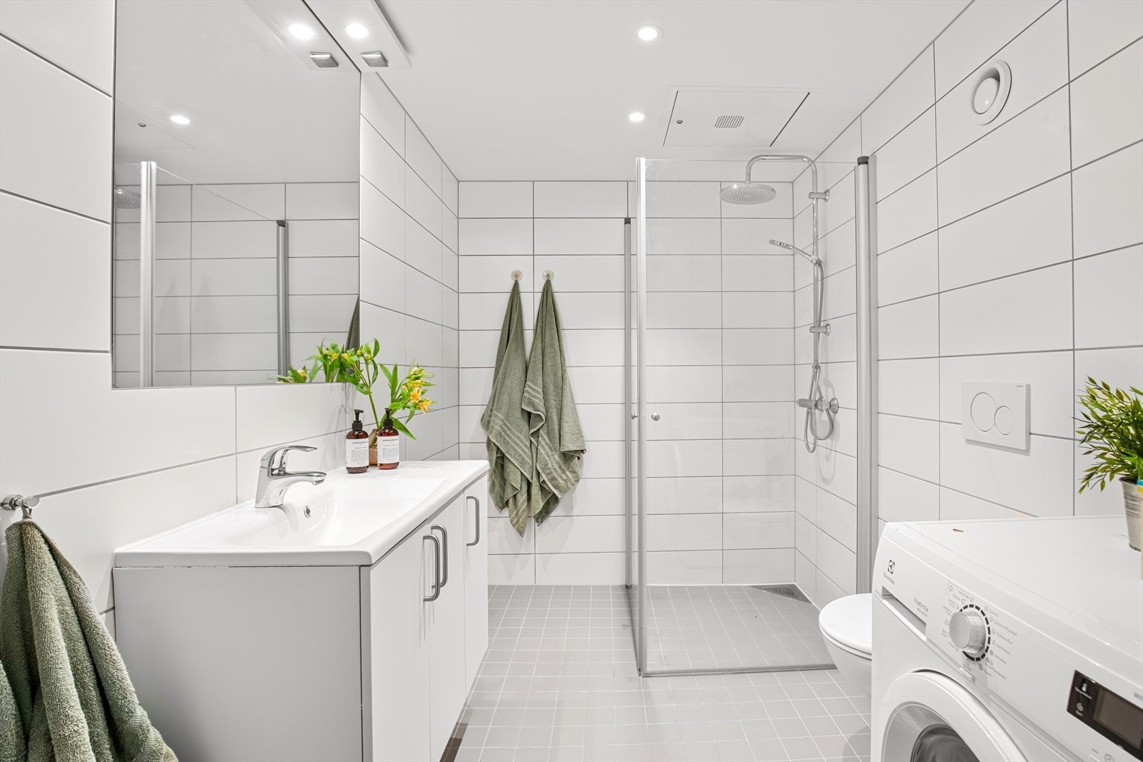 Delikat flislagt baderom med behagelig gulvvarme og downlight i tak. Det er installert regnfallsdusj i dusjsone. Galleribilde