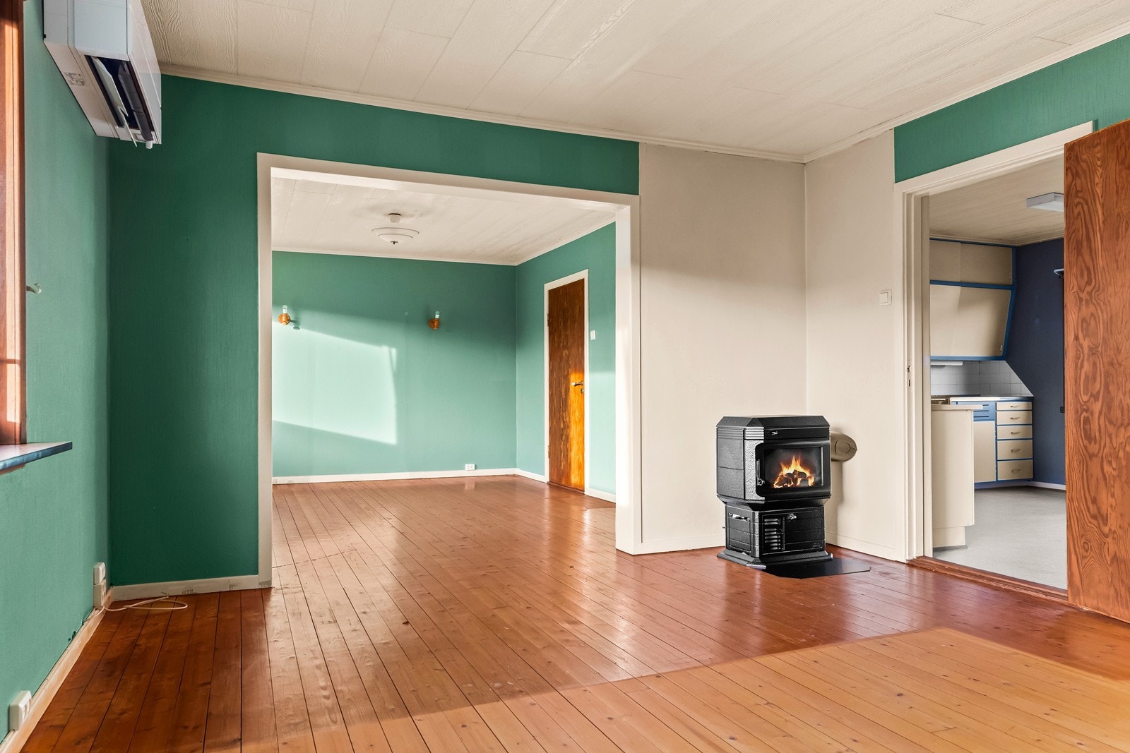 Rommet varmes opp av en Mitsubishi luft-til-luft varmepumpe fra 2019 og en parafin/vedovn. Galleribilde