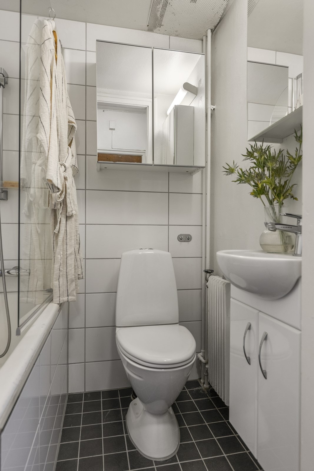 Flislagt bad. Servant med underskap i tillegg til speilskap Galleribilde